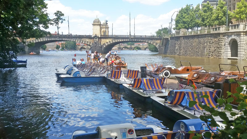 游艇和小溪停靠在河上vltava,后台有军团桥