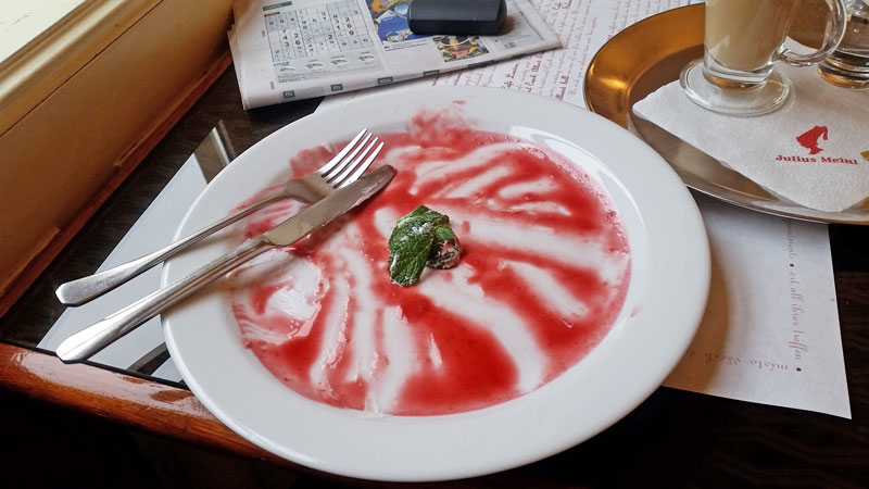 白盘剩菜树莓酱和插片薄荷刀叉