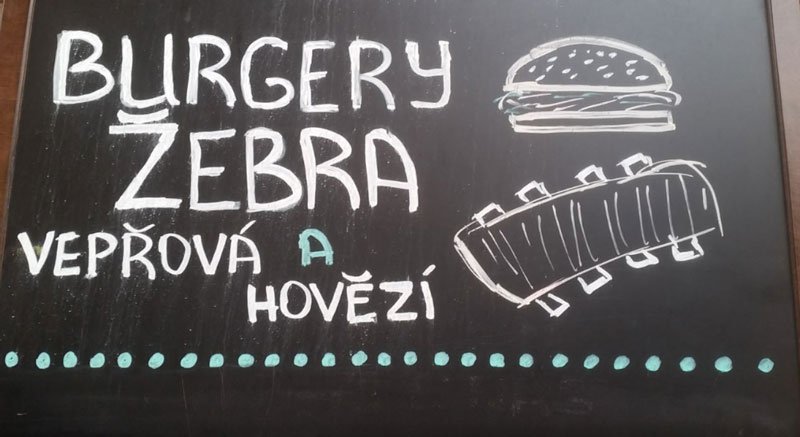 餐厅黑板显示汉堡和排骨切片,看起来像斑马,但实为猪排